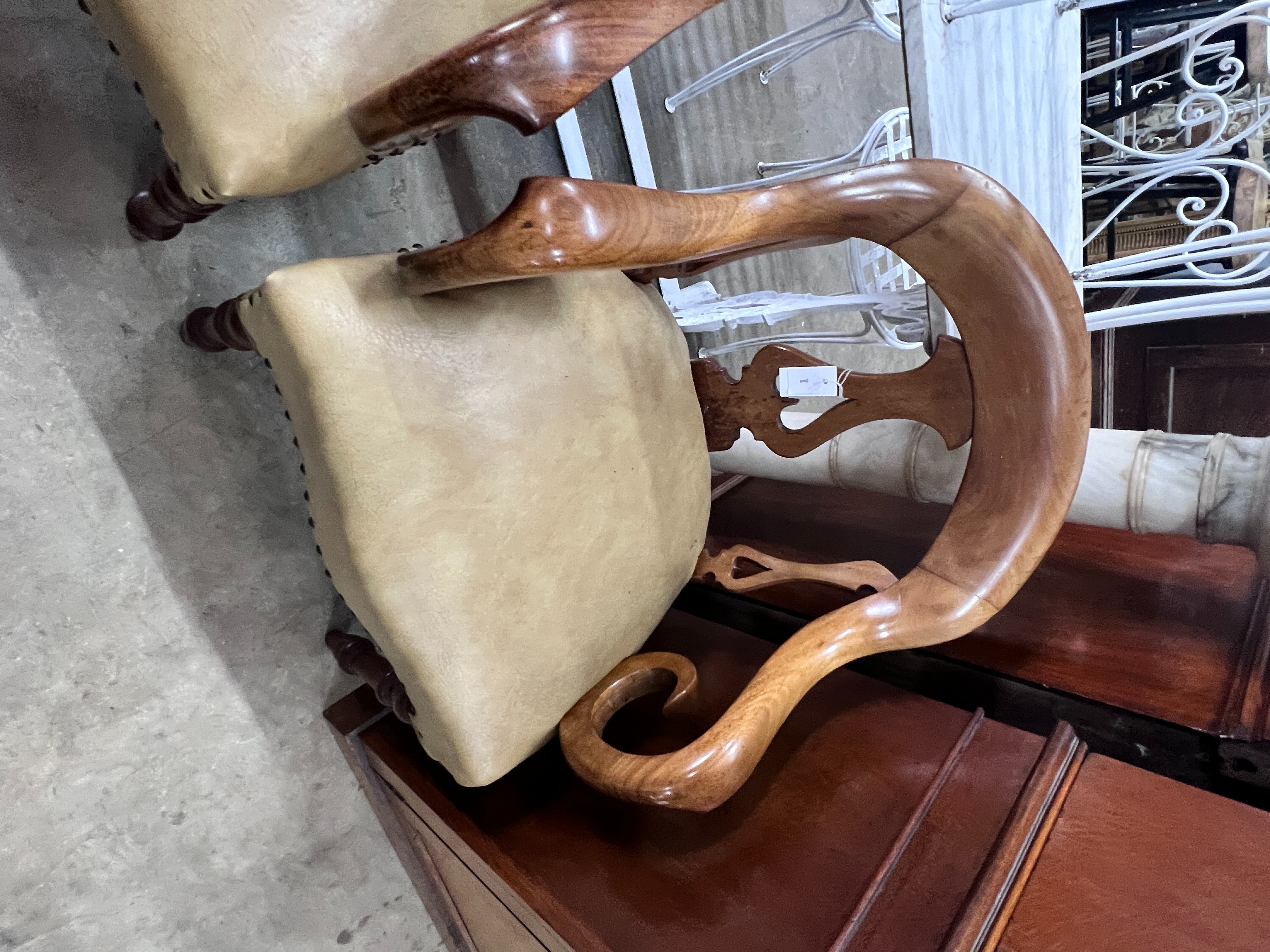 A pair of Victorian walnut elbow chairs with light brown leather seats, width 59cm, depth 51cm, height 90cm